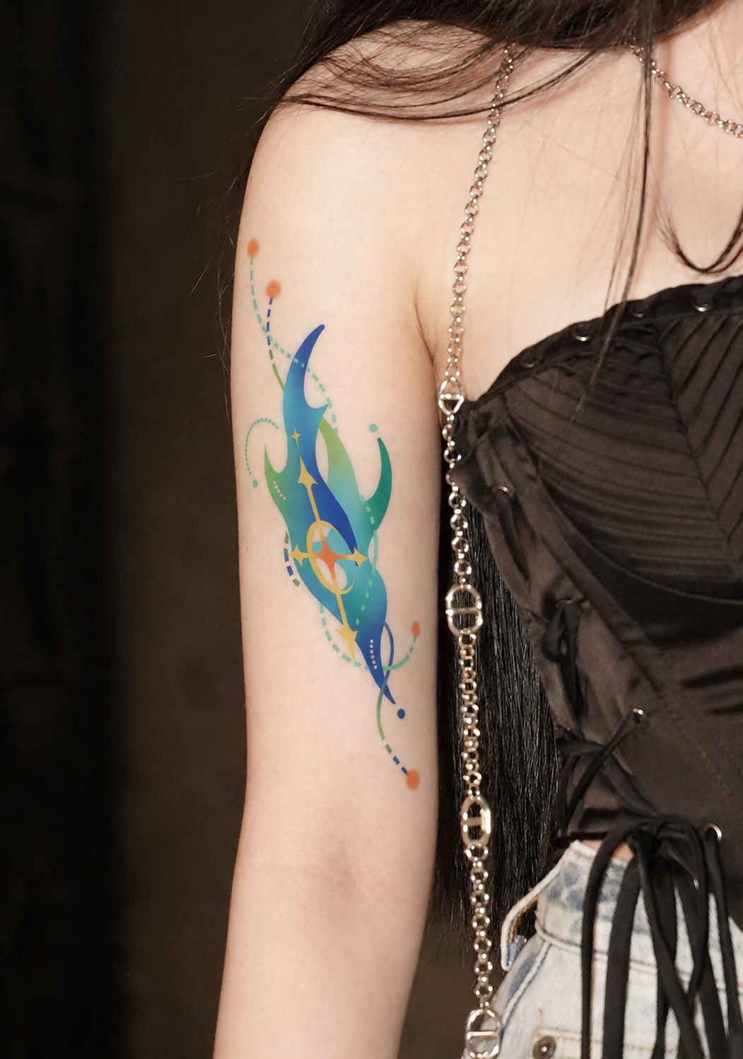 Blue and green abstract tattoo on upper arm