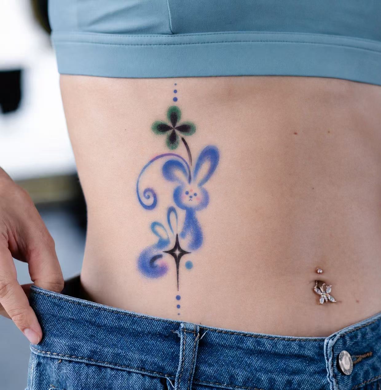 Blue rabbit and clover tattoo on waist